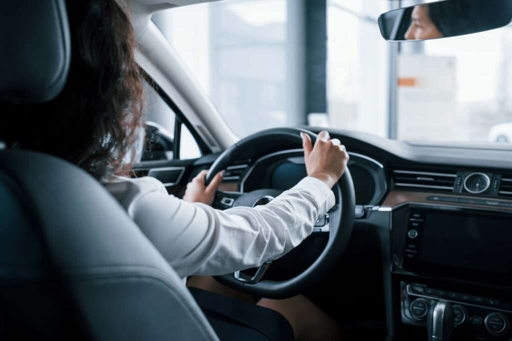 hands-steering-wheel-beautiful-businesswoman-trying-her-new-car-automobile-salon